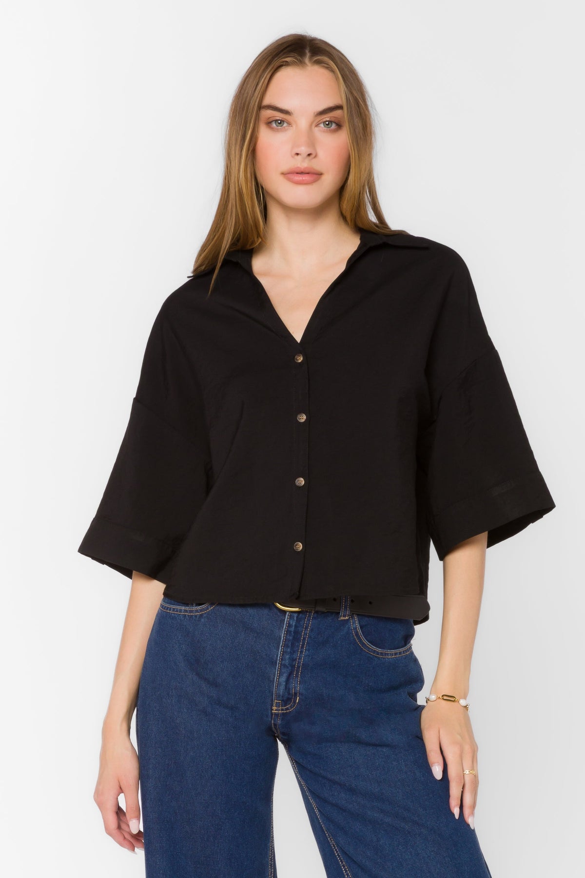 Minx Shirt in light blue viscose blend with collared y-neckline, front buttons, elbow sleeves, and high-low hem.