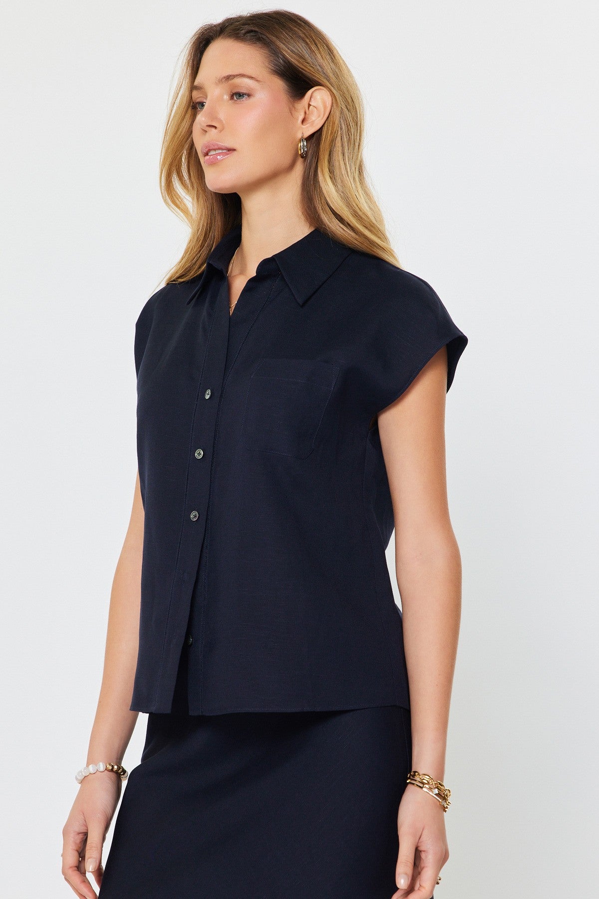 Madison cap-sleeve button-down blouse in a light neutral linen-rayon blend with a relaxed silhouette.