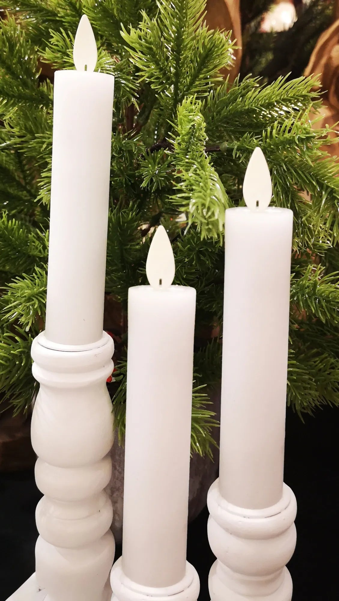 Set of three battery-operated flameless LED taper candles in neutral tones with a realistic dancing fire effect.