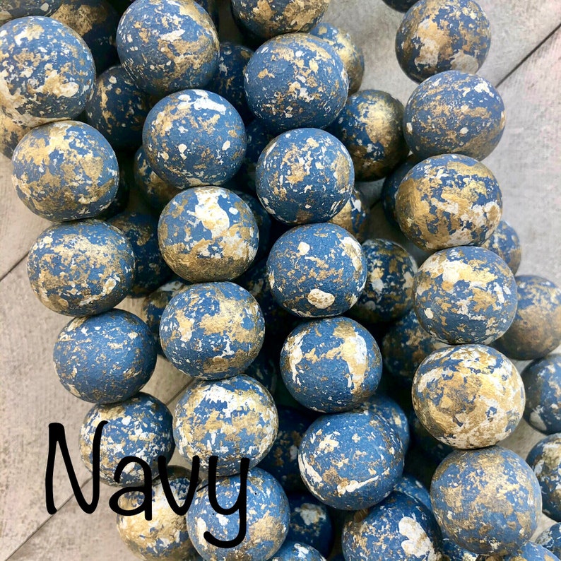 Handmade gold enameled clay cross blessing bead hanging from a doorknob