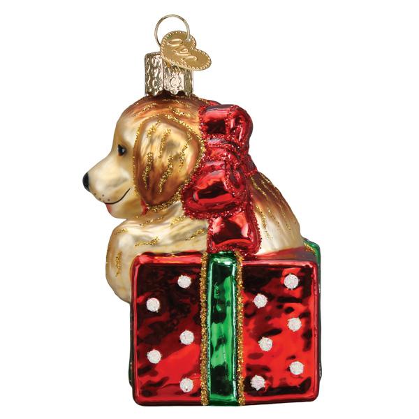 Golden Puppy Surprise glass ornament featuring a golden retriever puppy in a red polka dot gift box.