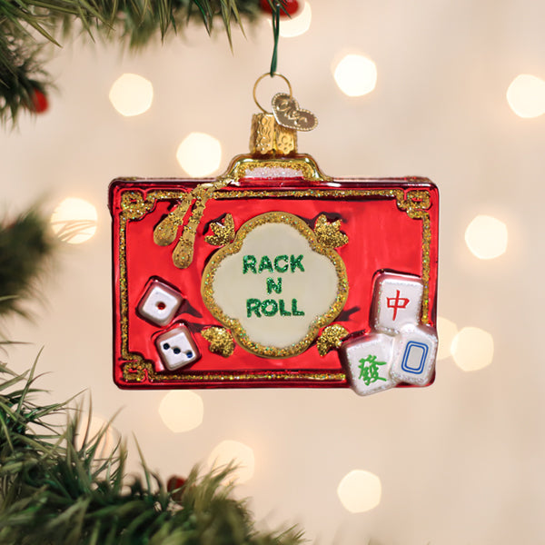 Red glass suitcase ornament with mahjong tiles, dice, and 'RACK N ROLL' in green glitter.