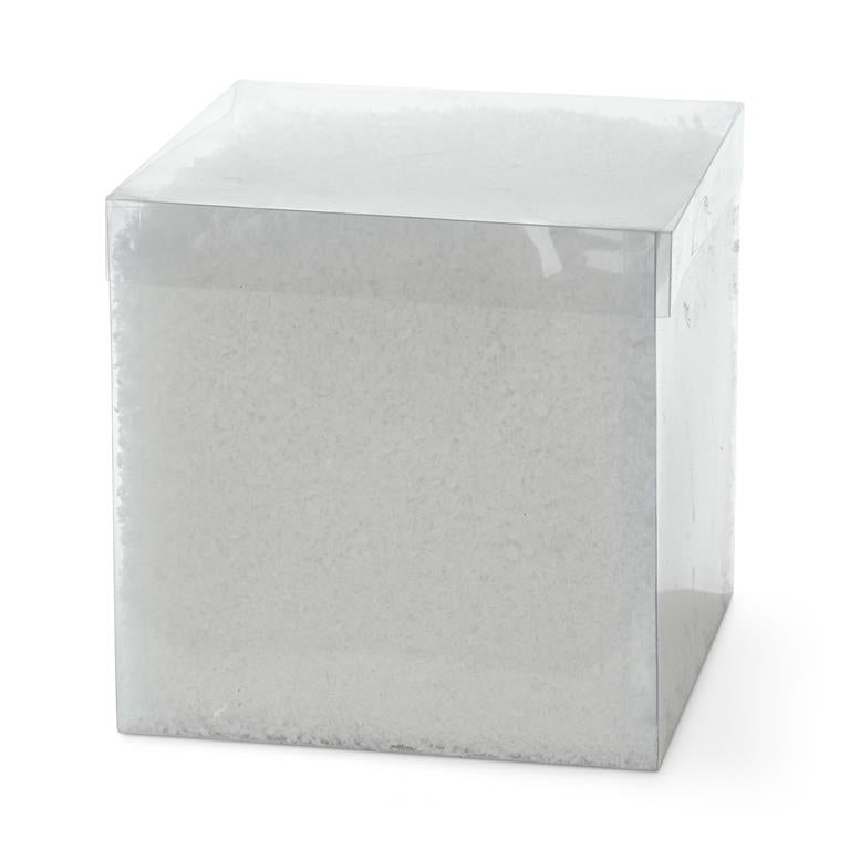 Square box containing white artificial snow with dimensions 5.5 inches high by wide and deep.