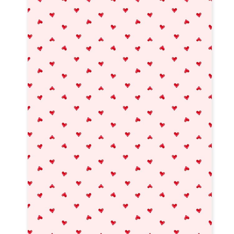 White paper table runner with a subtle sheen featuring a ditsy pattern of small hearts.