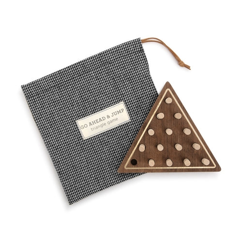 Wooden triangle game board with pegs and a black and white patterned drawstring bag.
