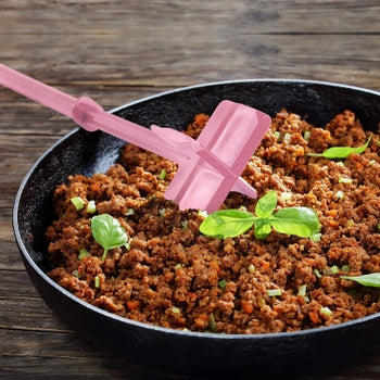 Pink heat resistant meat chopper and masher breaking up ground beef in a black skillet.