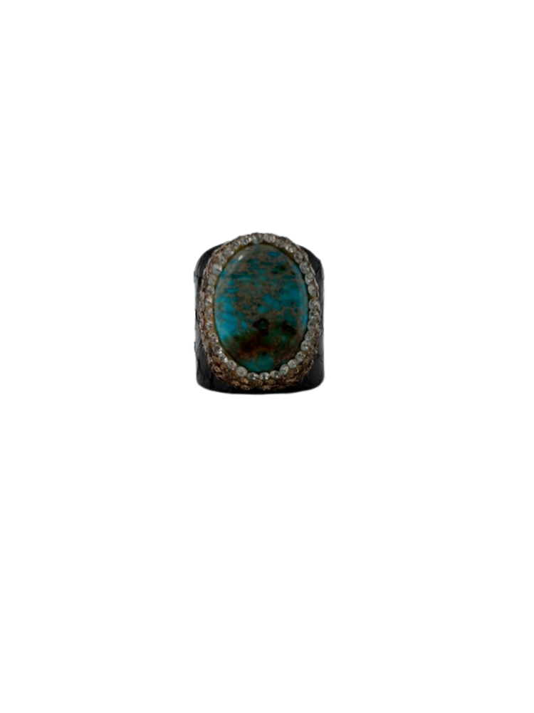 Fashion gemstone ring featuring an oval turquoise stone with a crystal halo on a dark textured band.