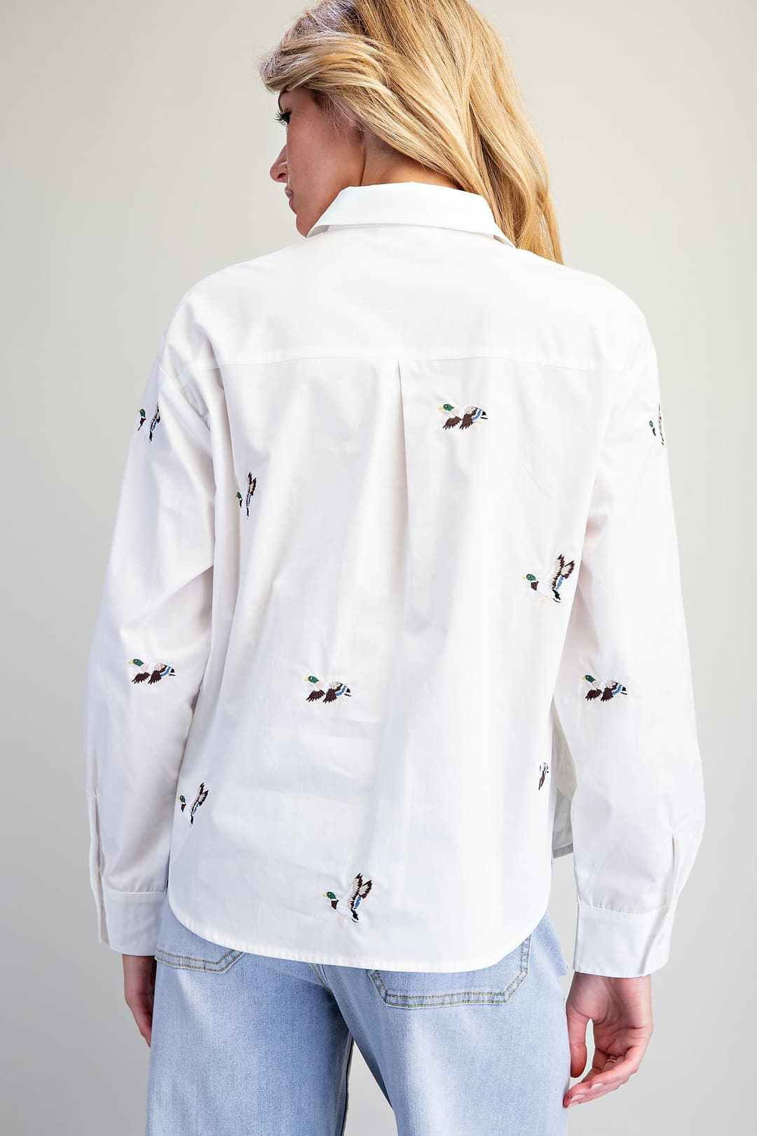 Back view of a white cotton button-down shirt with an all-over embroidered mallard duck motif.