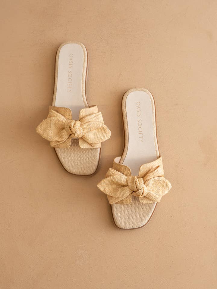 The Ginny Textured Bow Slide in a natural raffia-style fabric with a large bow on the strap.