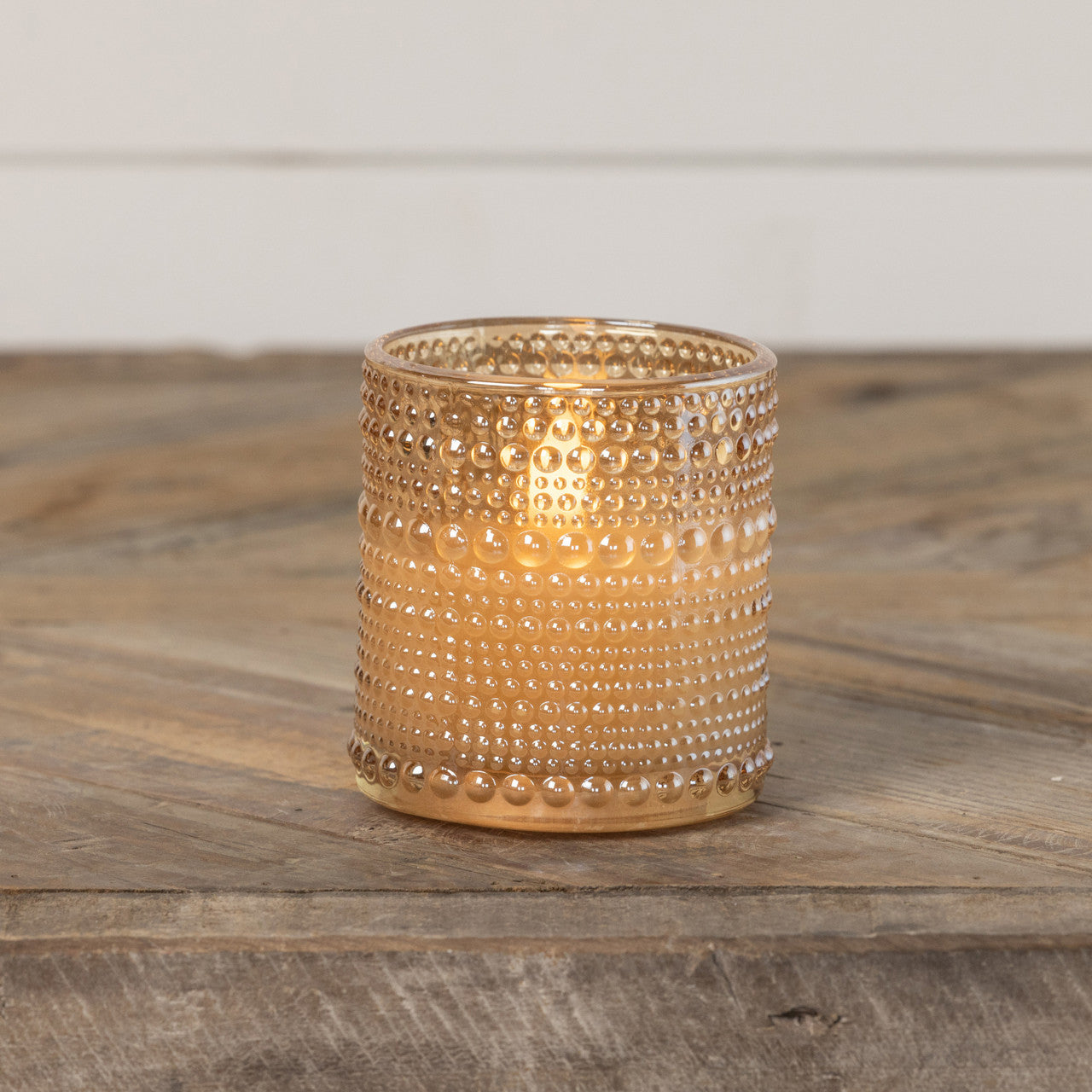 3D flame candle in a champagne-colored glass jar with dotted pattern
