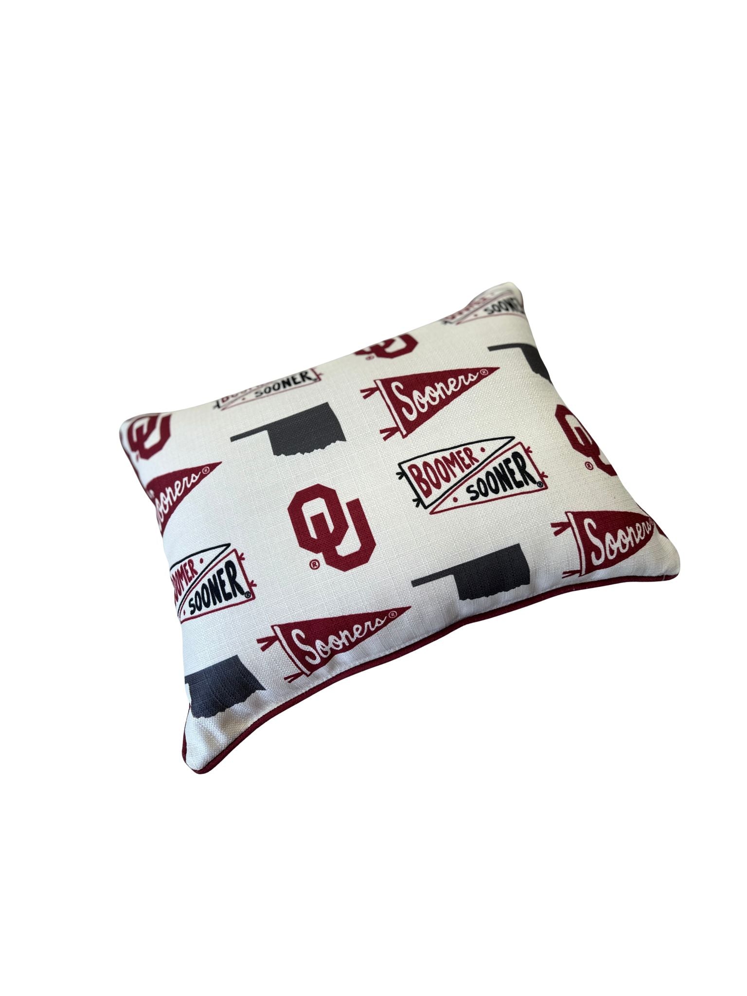 Oklahoma Sooners collegiate cluster pillow with crimson piping and team logos on white fabric.