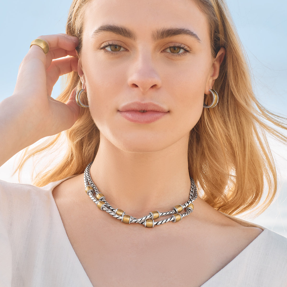 Woman wearing Meridian Geo Small Hoop Earrings in a two-tone silver and gold-brushed finish.