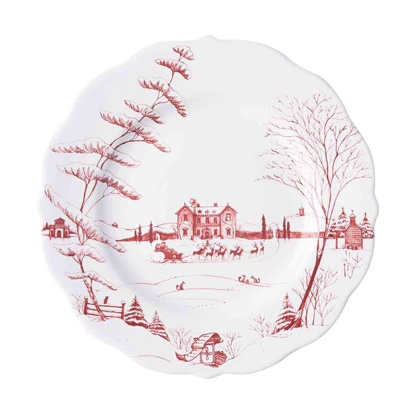 White ceramic dinner plate with a red winter scene featuring a manor house, sleigh, and trees.