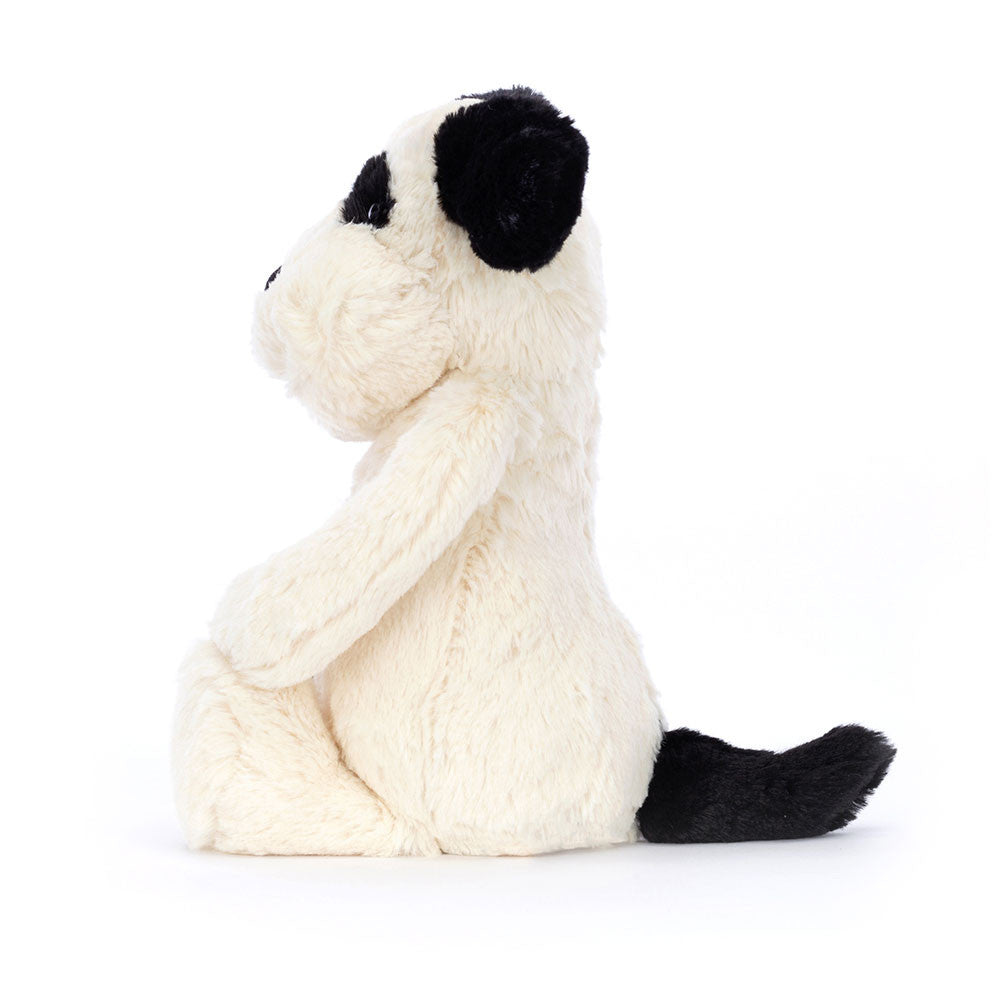 Side view of a Bashful Black & Cream Puppy plush toy sitting with a black ear, eye patch, and tail.