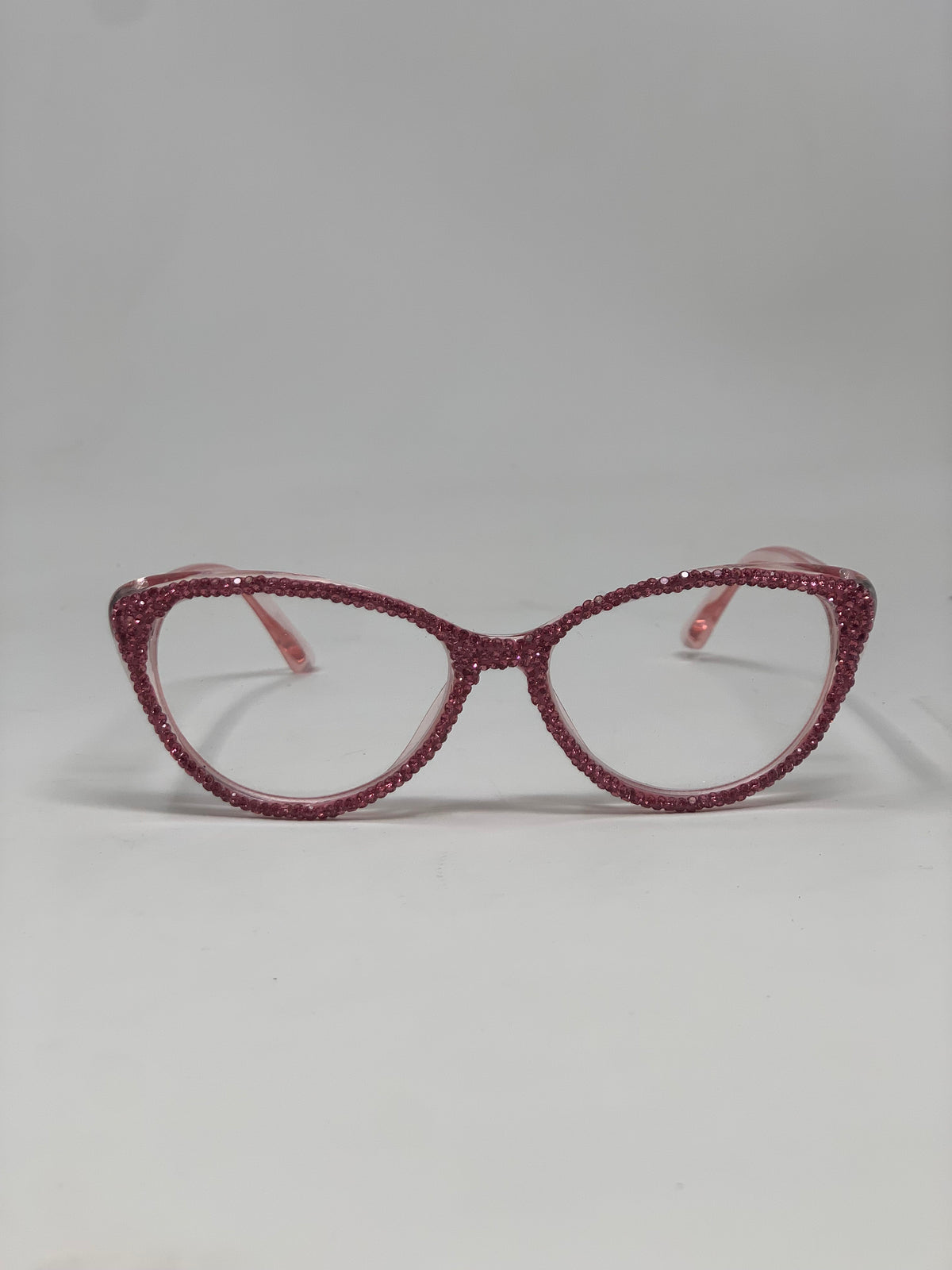 Pink cat-eye reading glasses with frames fully covered in shimmering pink rhinestones.