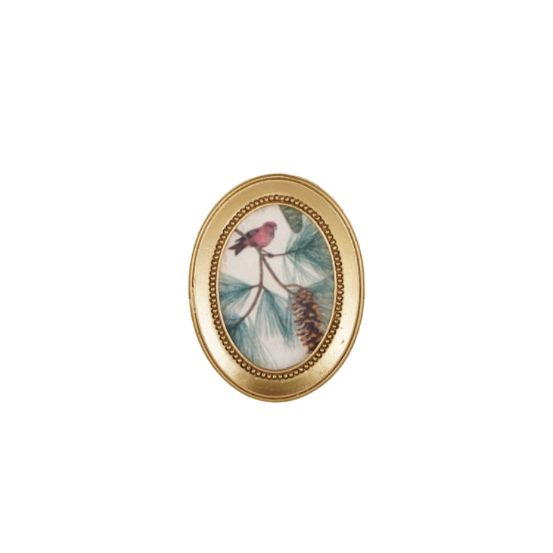Oval gold-framed magnet featuring a vintage-style illustration of a red bird on a pine branch.