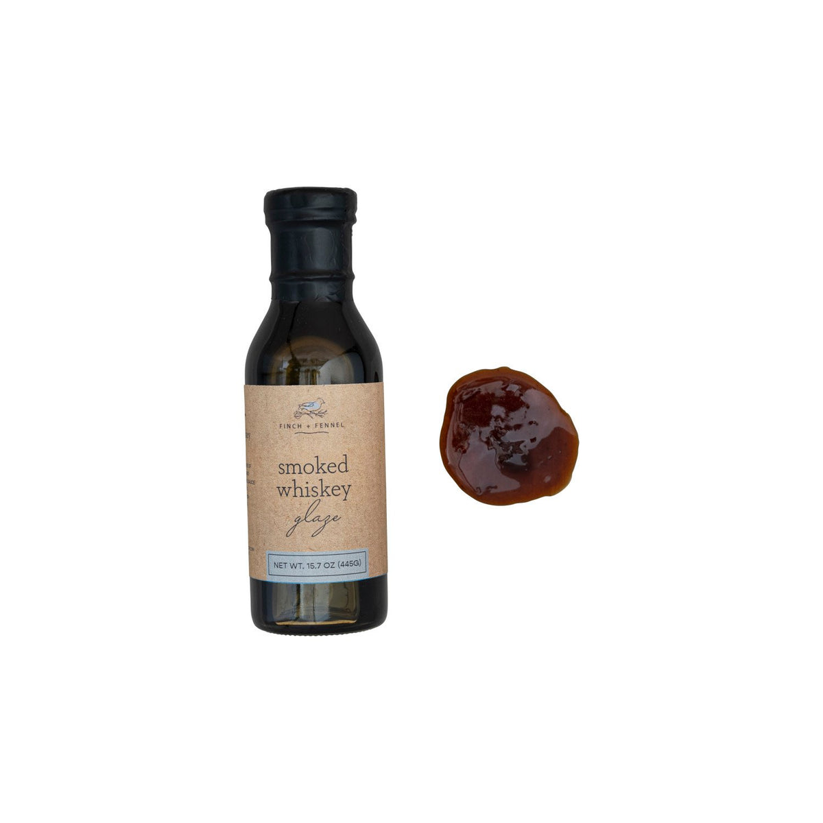 A bottle of Finch + Fennel Smoked Whiskey Glaze next to a sample of the dark brown sauce.