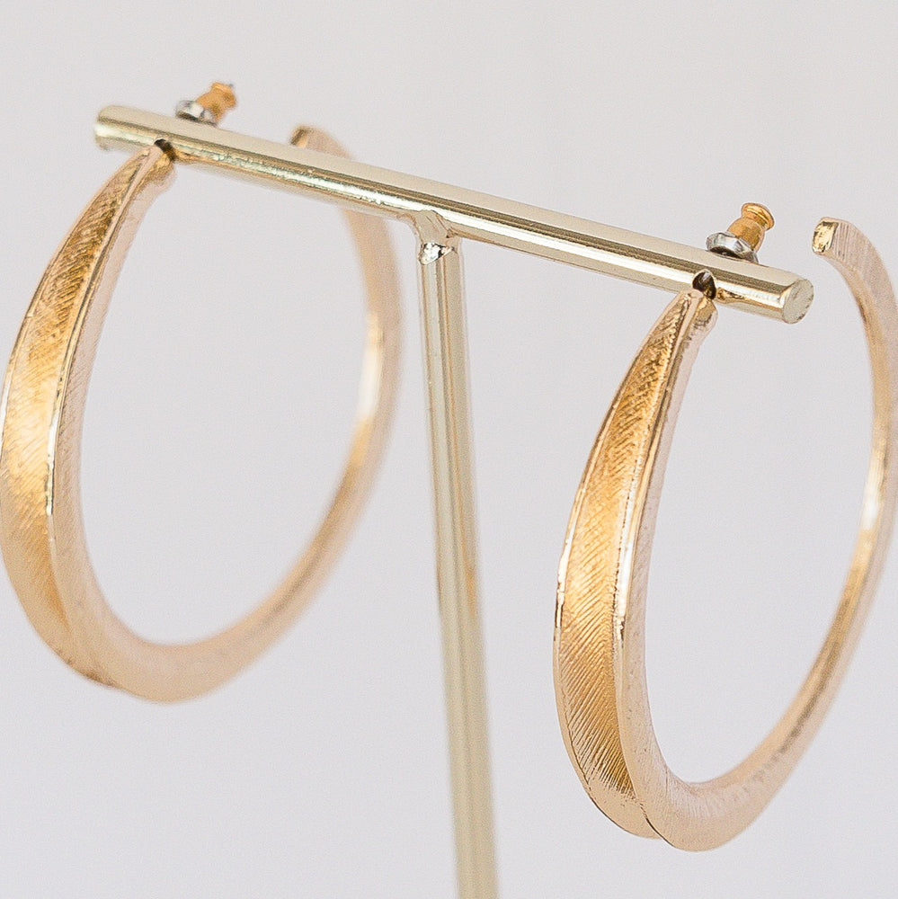 Layla Brushed Hoop earrings in a brushed gold finish with a smooth circular silhouette.