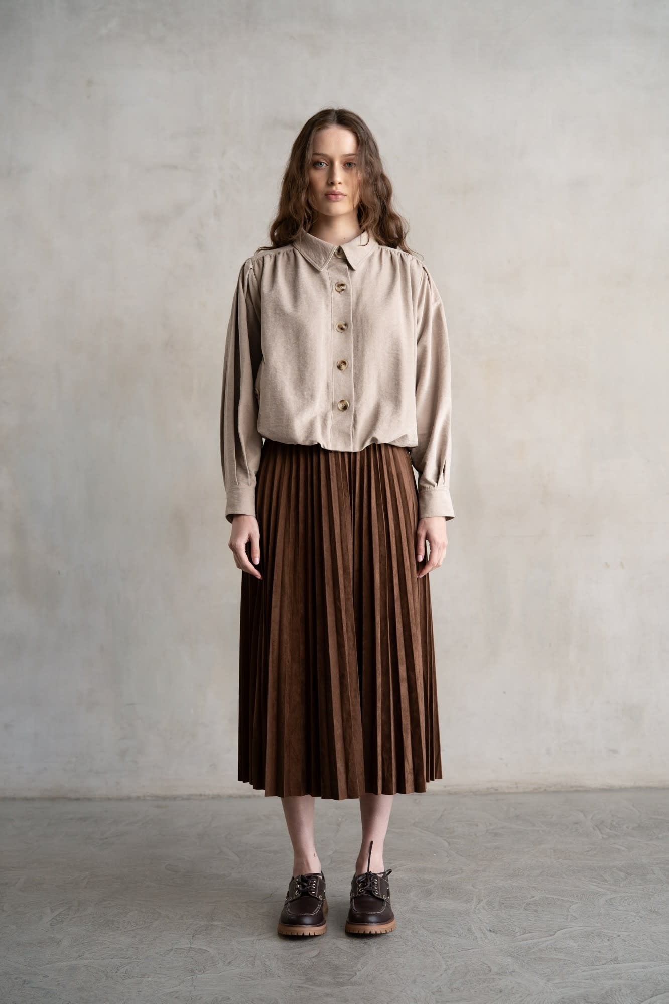 Maddie elastic waist pleated midi skirt in light beige with a soft sheen and structured silhouette.
