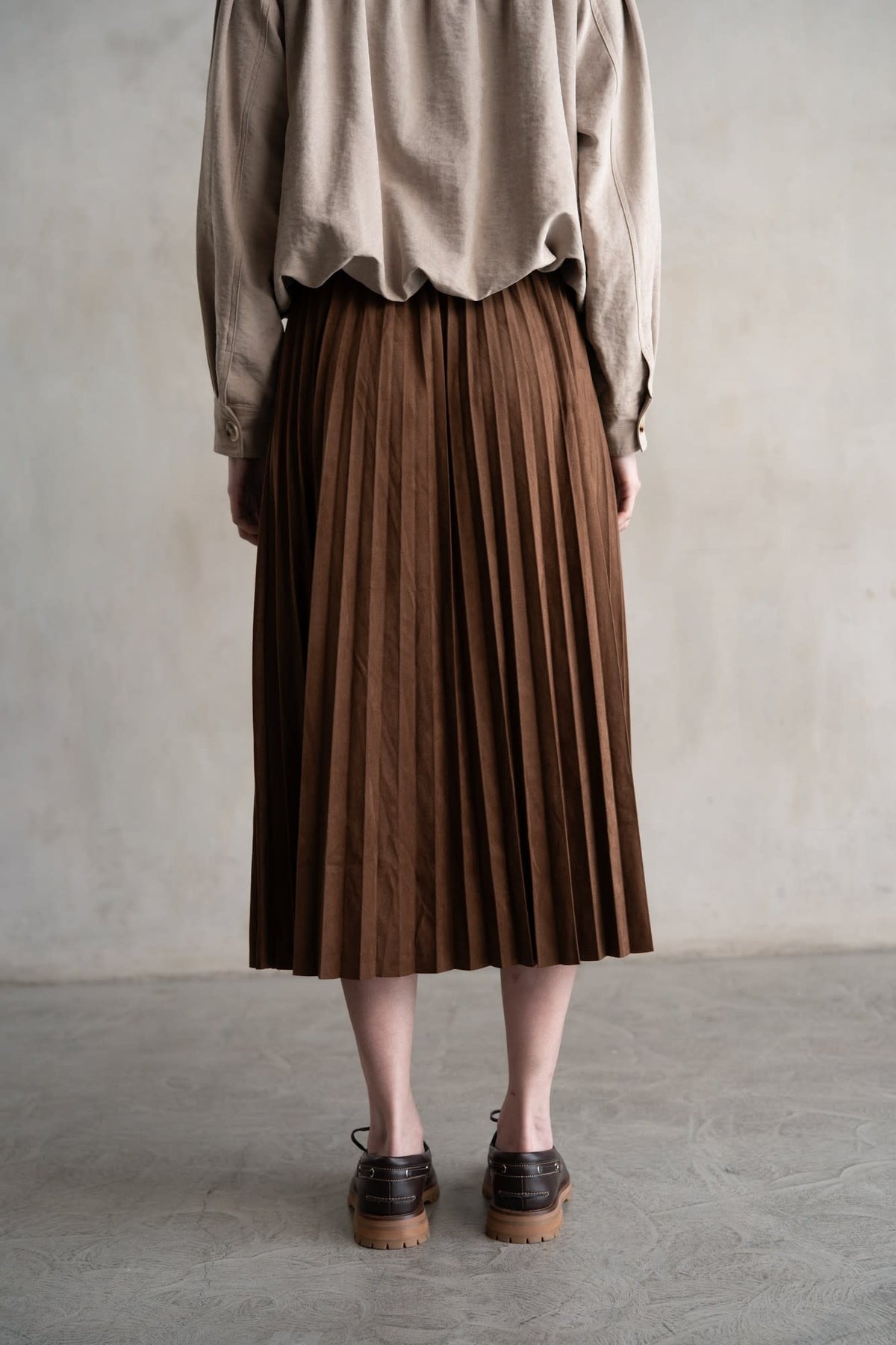 Maddie elastic waist pleated midi skirt in soft sheen fabric with a structured silhouette and high-rise waistband.