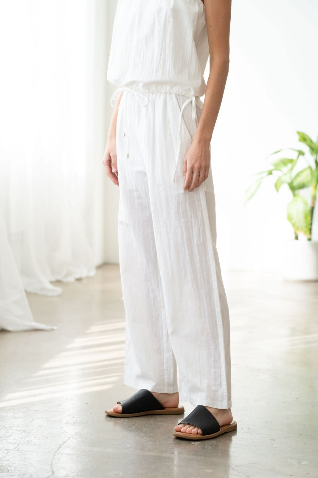White wide-leg linen pants with elastic waistband and front pockets