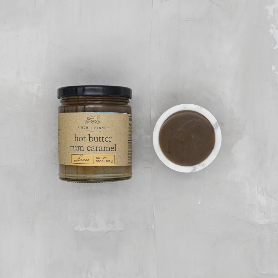 Bottle of hot butter rum caramel sauce with a rich amber liquid visible through clear glass.