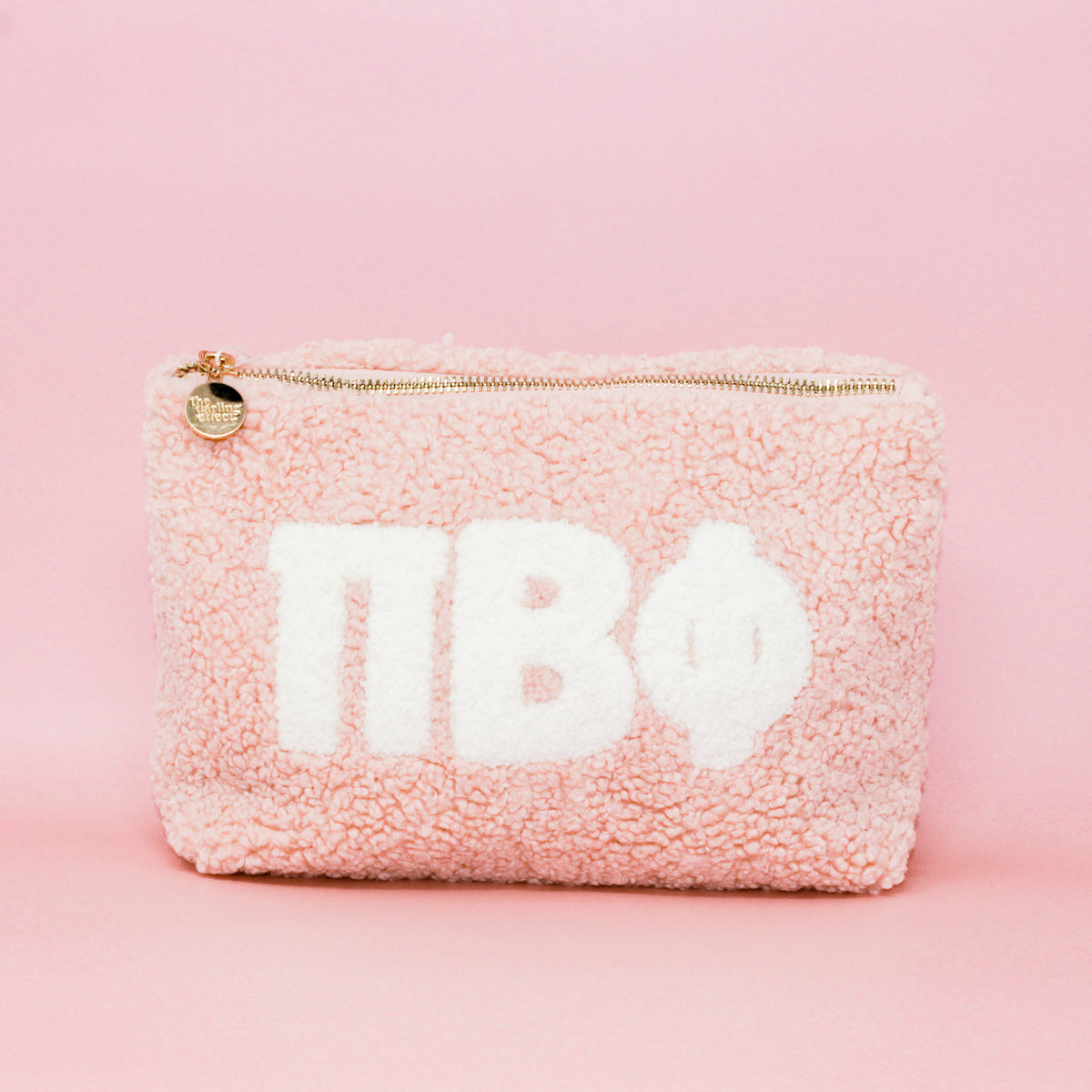 Blush sorority teddy letter pouch with soft plush texture.