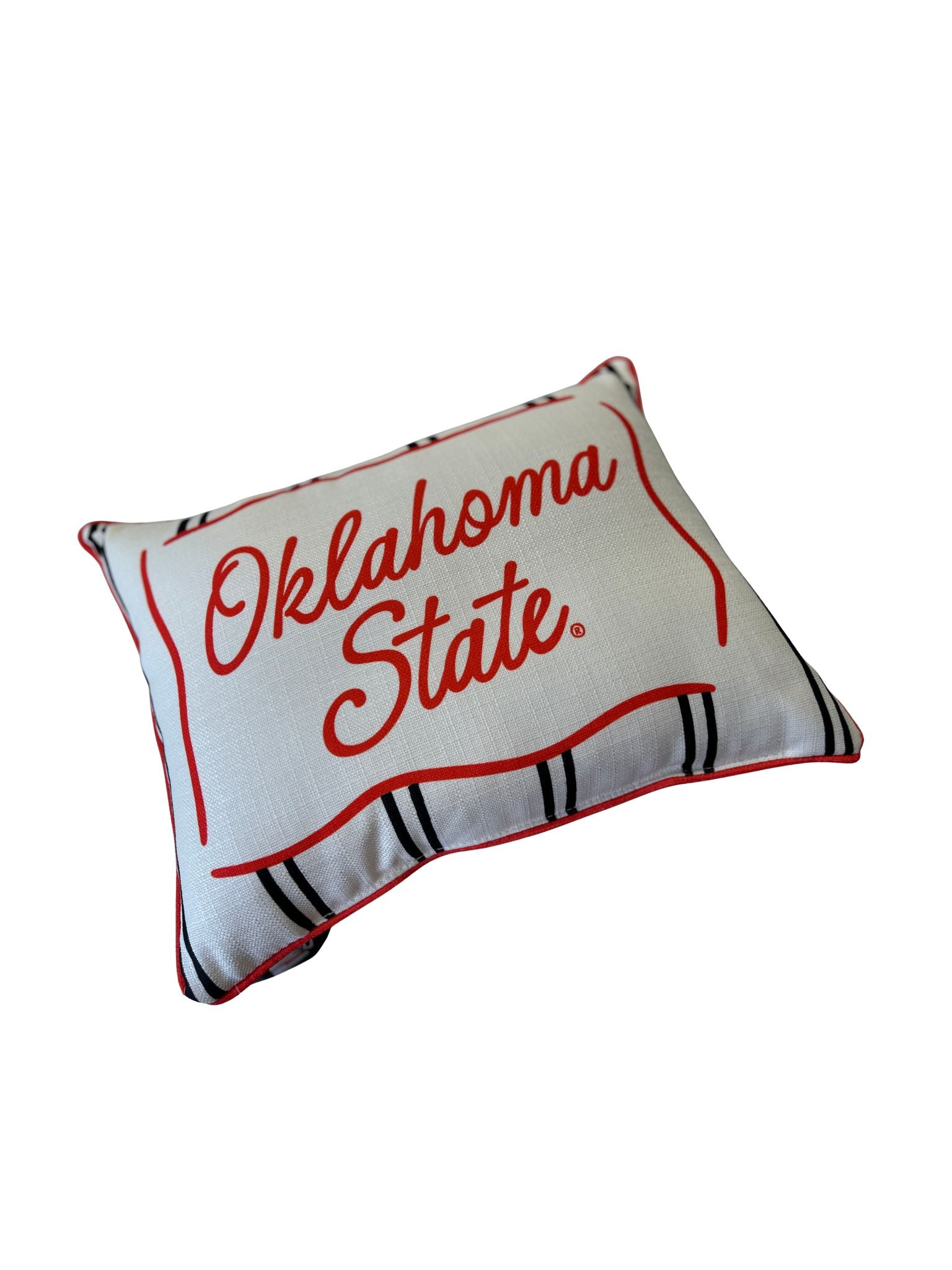 White rectangular pillow with red Oklahoma State script, red piping, and black stripes.
