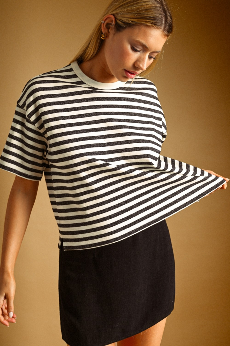 Woman wearing a Celine Bold Striped Short Sleeve Top in black and white with a black skirt.