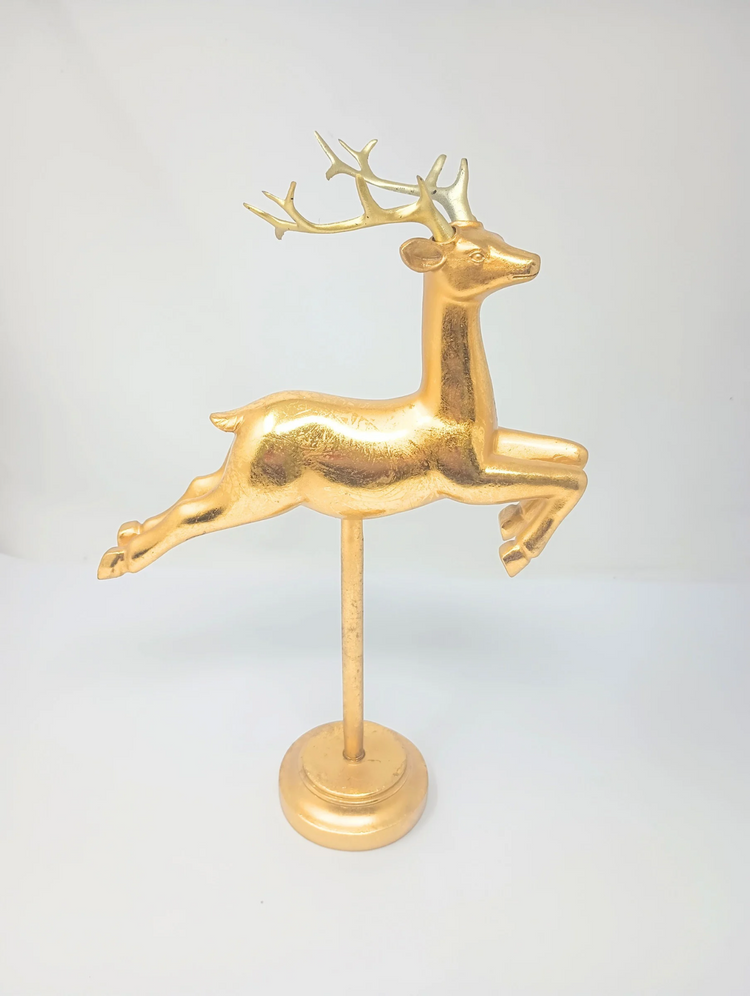 Gold flying reindeer figurine on a matching gold pedestal stand.