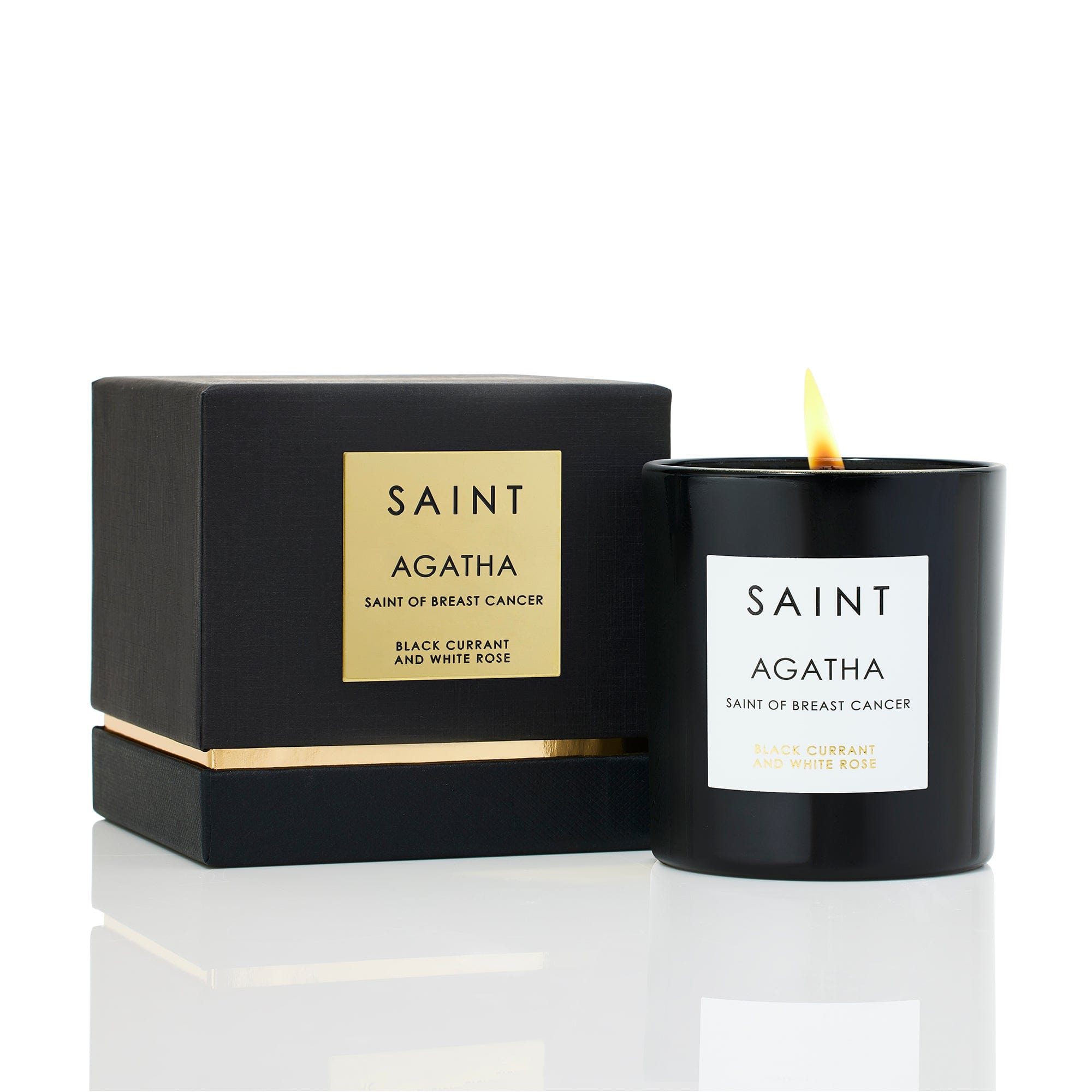 White ceramic candle holder with a lit Saint-themed pillar candle inside.