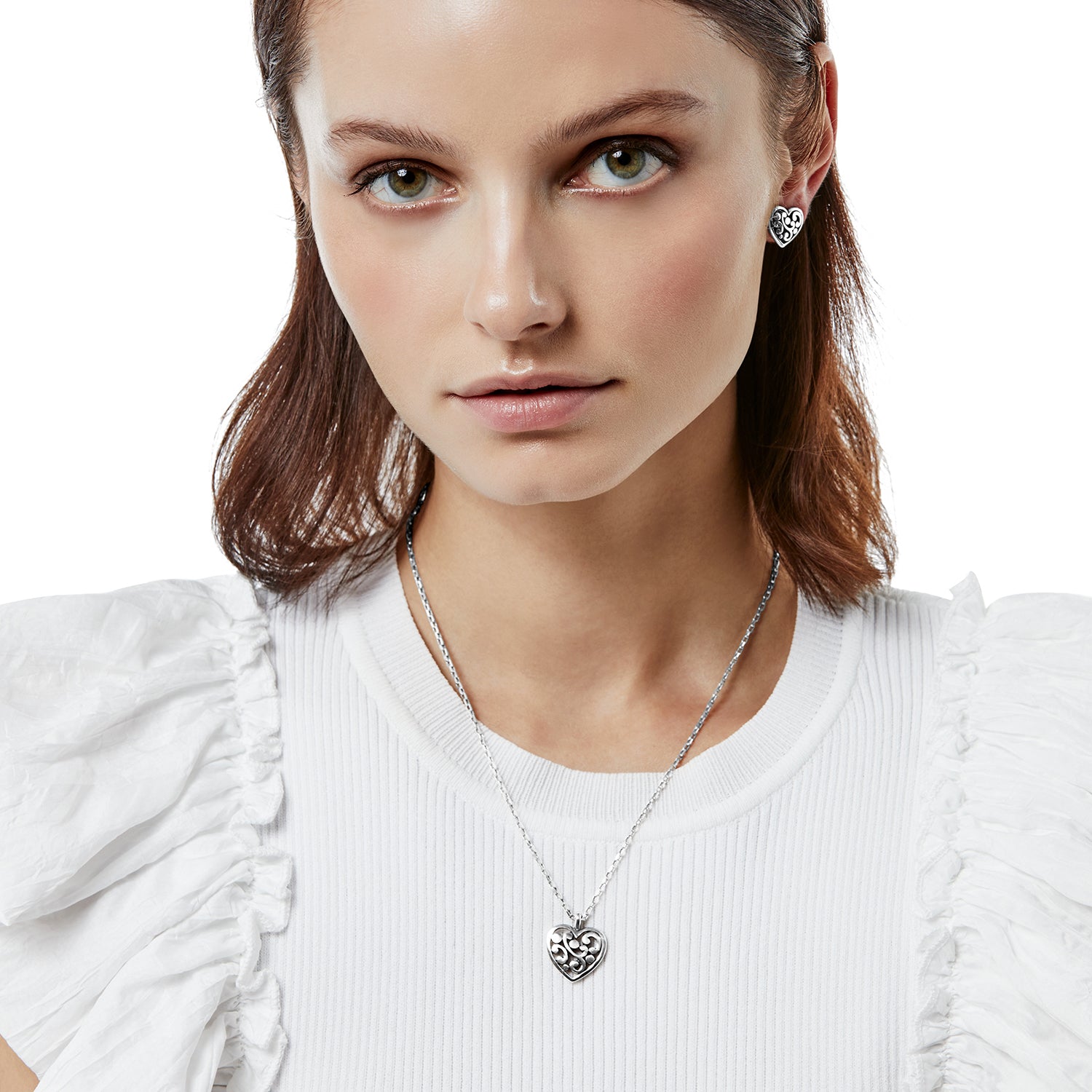 Woman wearing the silver-plated Contempo Heart Petite Necklace with a filigree heart pendant.