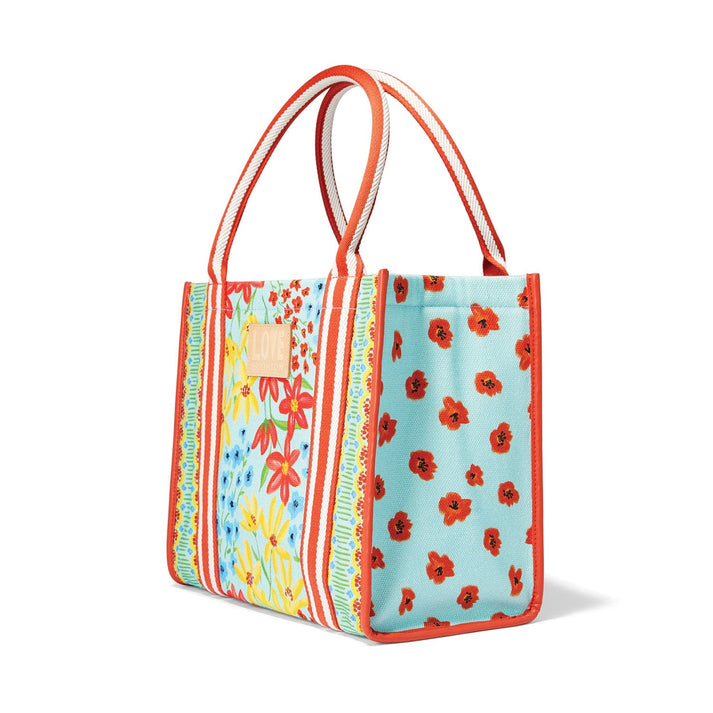 Painterly Garden Canvas Carryall with blue floral print, orange trim, and striped handles.