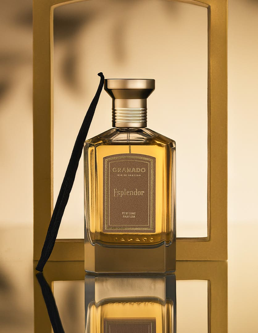 Esplendor Eau de Parfum by Granado in a glass bottle with a gold cap and a vanilla bean.