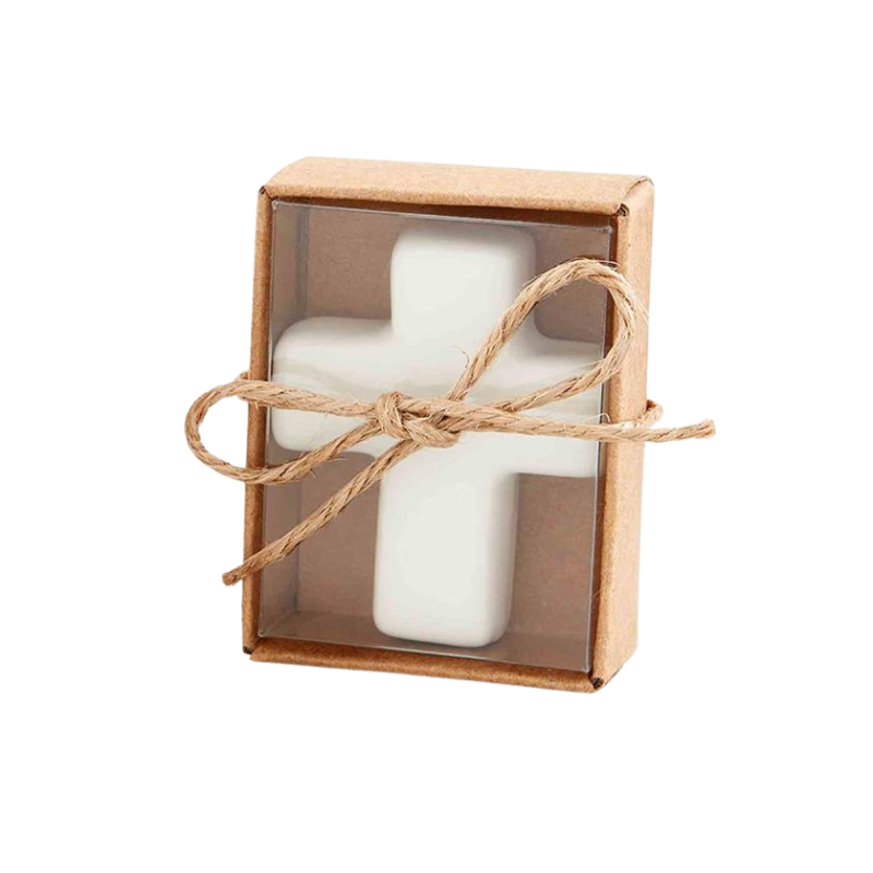 White mottled ceramic cross in a small brown kraft box with a clear window and twine bow.