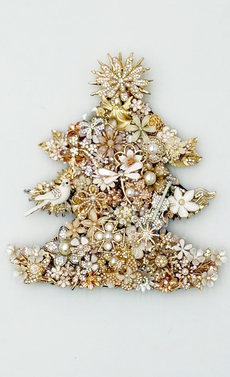 A Christmas tree shape made of gold and pearl brooches, with a star on top and a bird on the left.