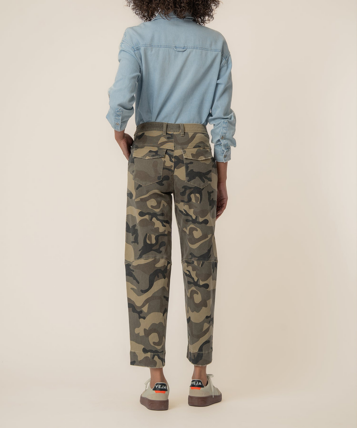 Rear view of a person wearing Ashton Wide Leg Barrel camo pants with a light blue denim shirt.