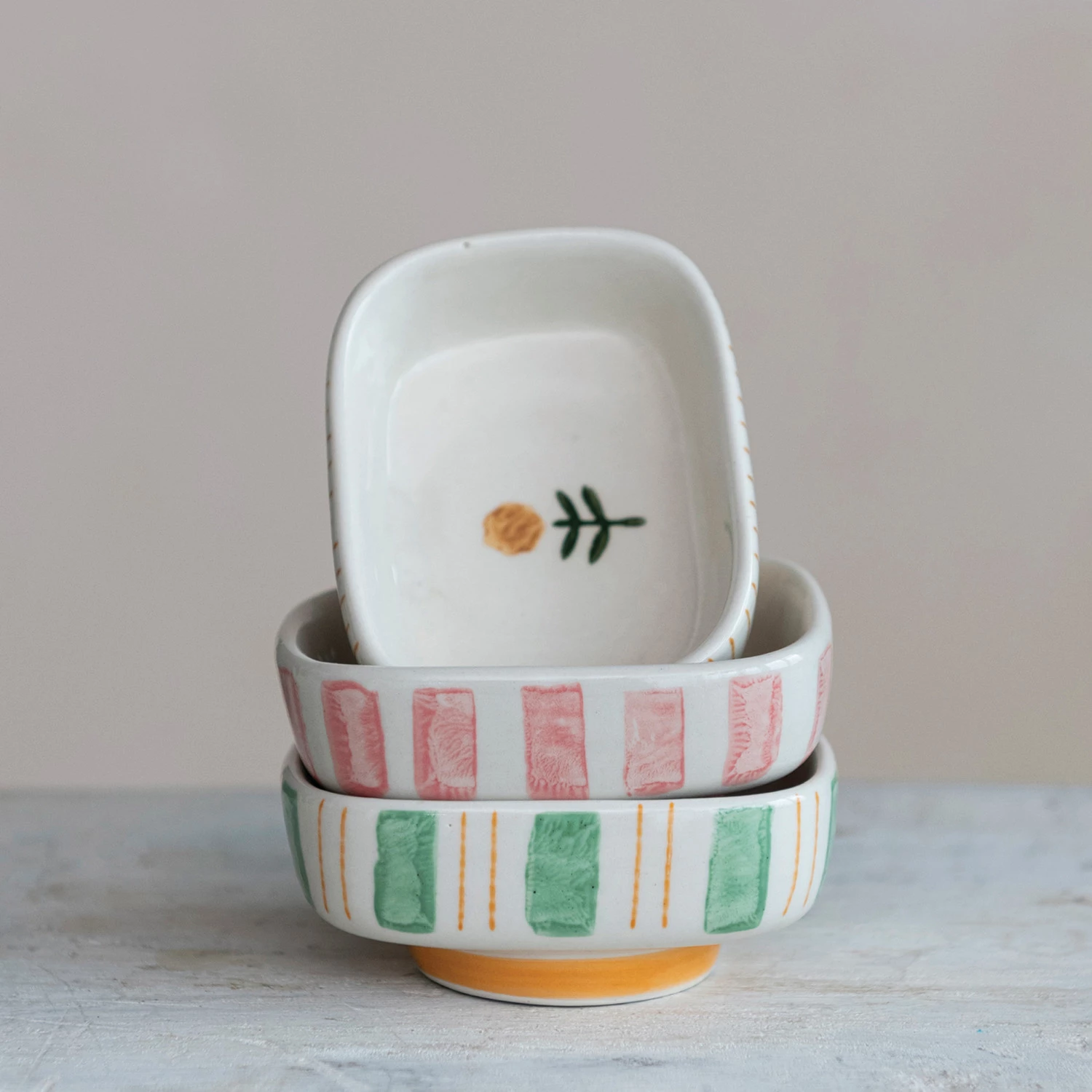 Hand-painted stoneware dish featuring blue stripes and a floral pattern with an oval silhouette.