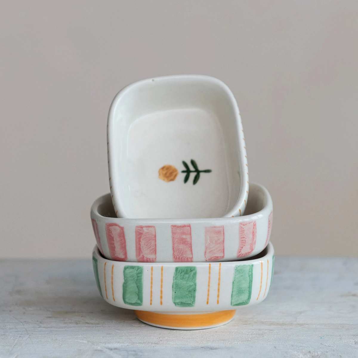 Hand-painted stoneware dish featuring blue stripes and a floral pattern with an oval silhouette.