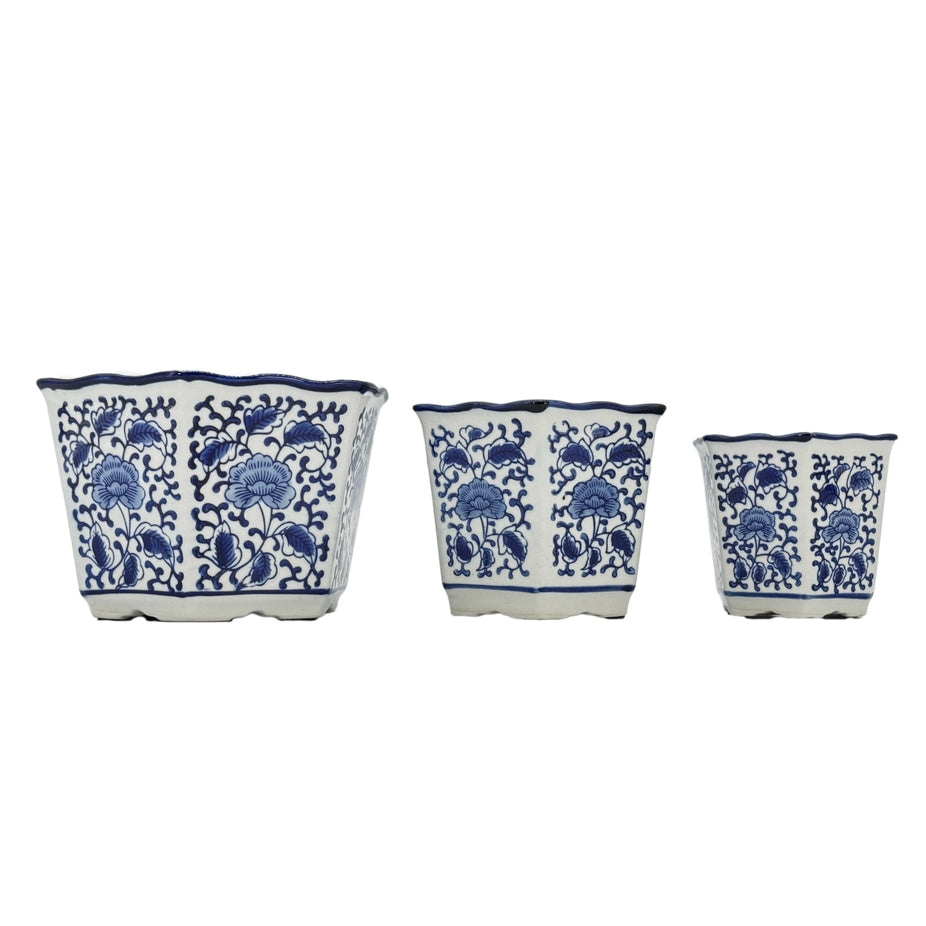 Three blue and white hexagon ceramic planters with floral patterns and ruffled lips in varied sizes.