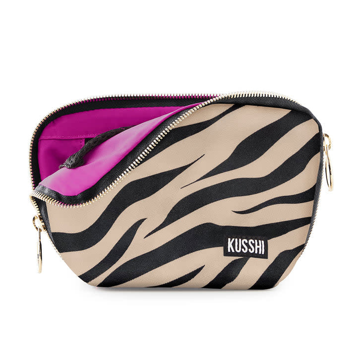Zebra print fuchsia fabric makeup bag with gold hardware and three-sided zipper.