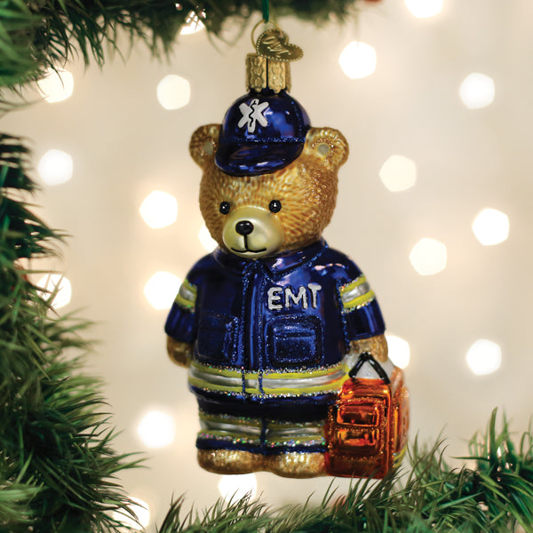 EMT Teddy Bear glass ornament wearing a blue uniform and hat, holding an orange medical bag.