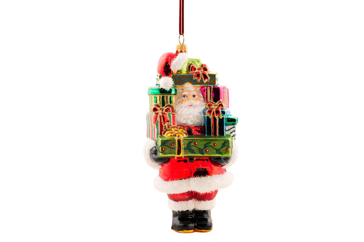 Hand-blown glass Santa ornament peeking through a stack of colorful, hand-painted gifts.