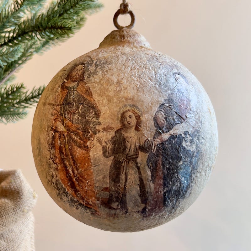 Large 6-inch metal ball ornament with an aged finish featuring a vintage Holy Family illustration.