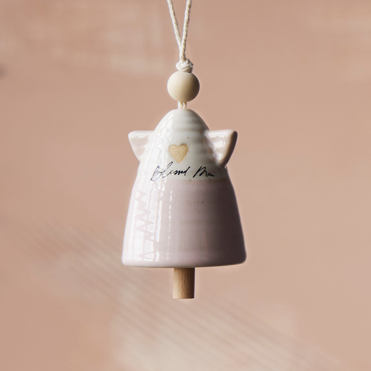 Small stoneware bell with wood accents in natural tones