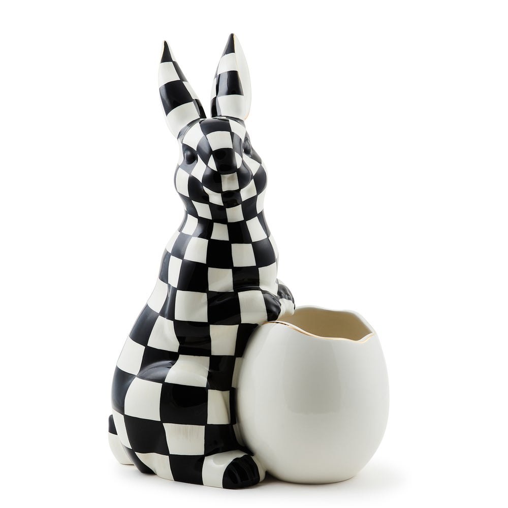 Large ceramic bunny vase with black and white checkered pattern holding a white egg-shaped vessel.