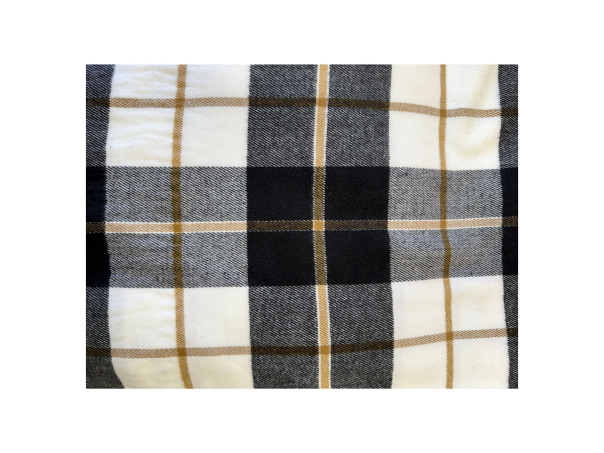 Close-up of a Scottish plaid cashmere scarf in white, black, grey, and tan checkered patterns.