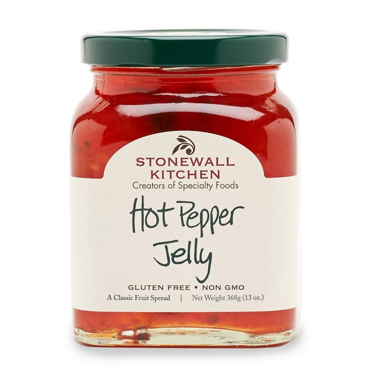 Glass jar containing red hot pepper jelly with visible onion pieces.