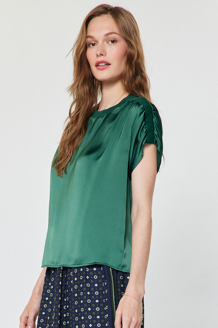 Mina round neck short sleeve cropped blouse in polyester satin with gathered shoulders.