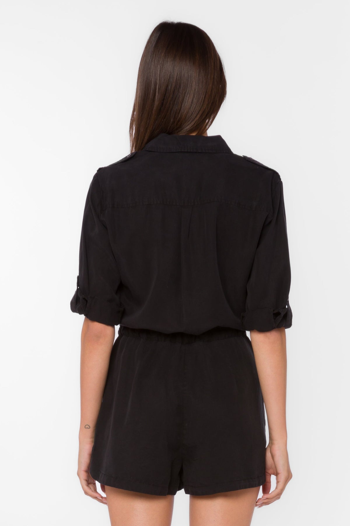Black TENCEL™ lyocell romper with collared V-neckline, rolled long sleeves, utility tabs, and porkchop pockets.